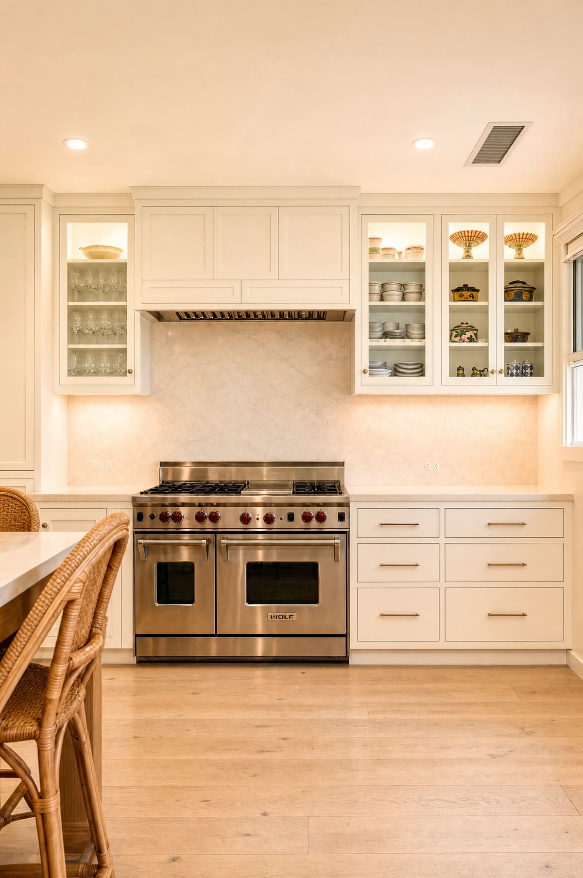 White kitchen with glass-front cabinetry and a Wolf range