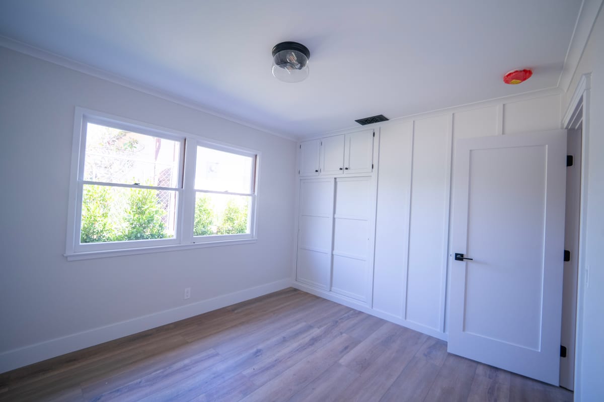 Finished empty room with built-in millwork and a wall of windows