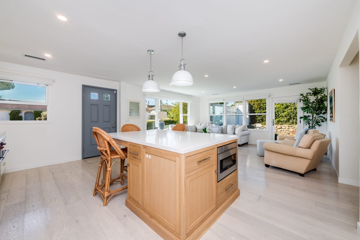 Kitchen island with pendant lighting opening to the living room