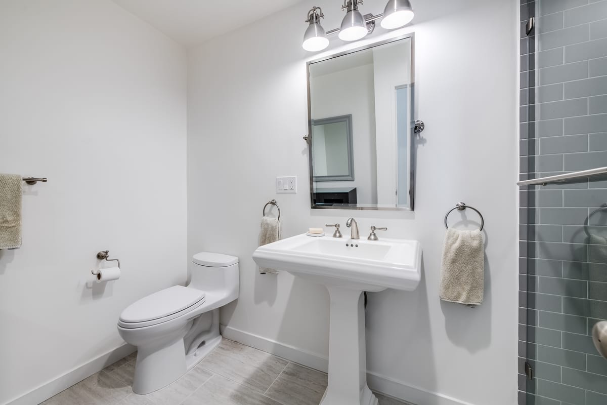 Powder room with a pedestal sink and glass shower door
