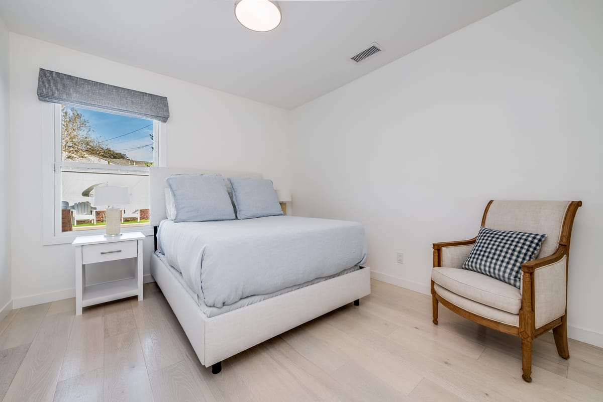 Guest bedroom with a garden view and reading chair