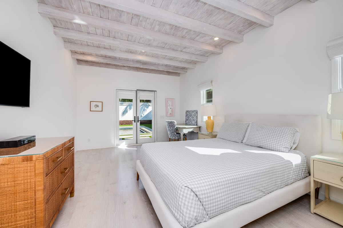 Guest bedroom with a whitewashed exposed-beam ceiling