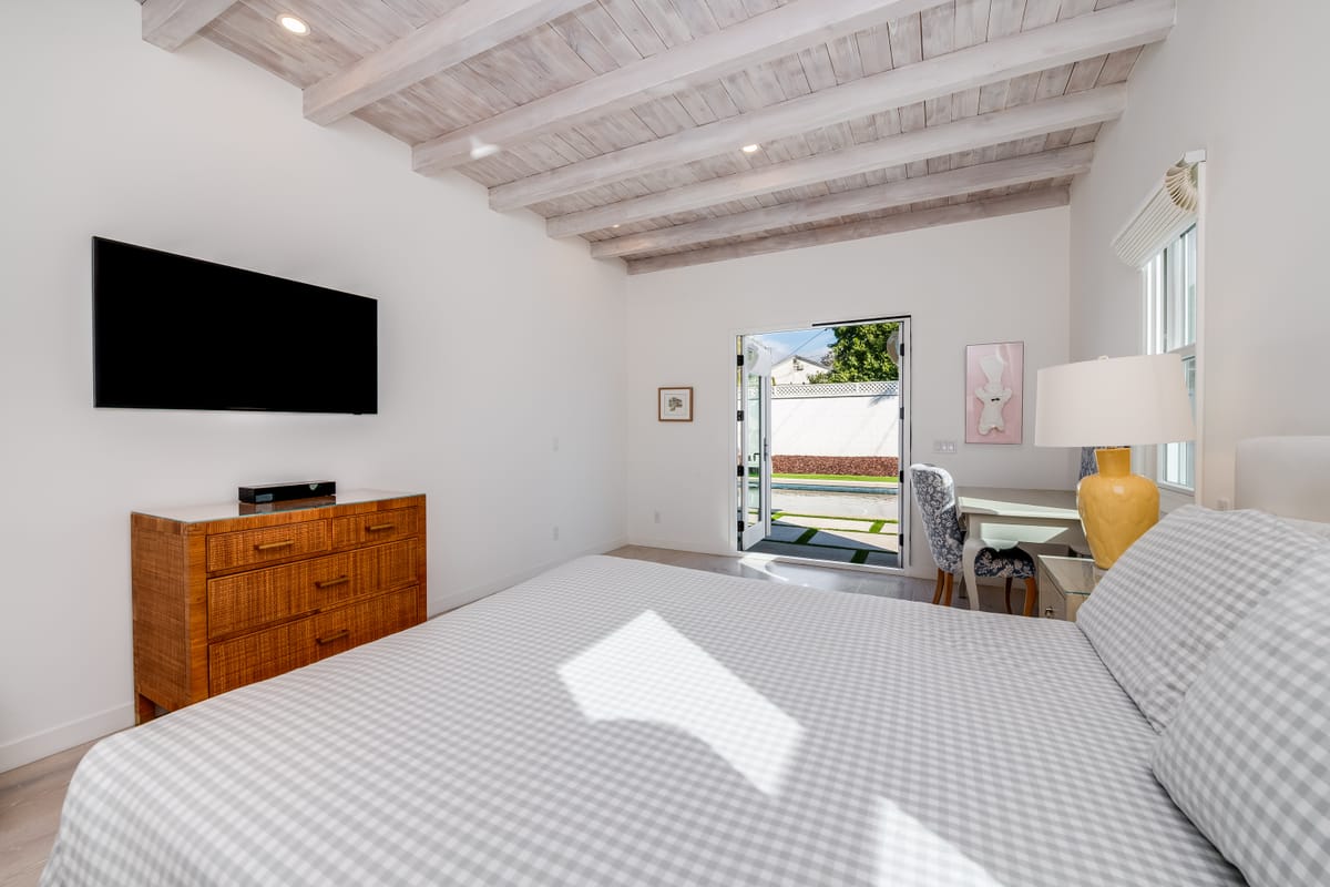 Bedroom with an exposed-beam ceiling and French doors to the yard