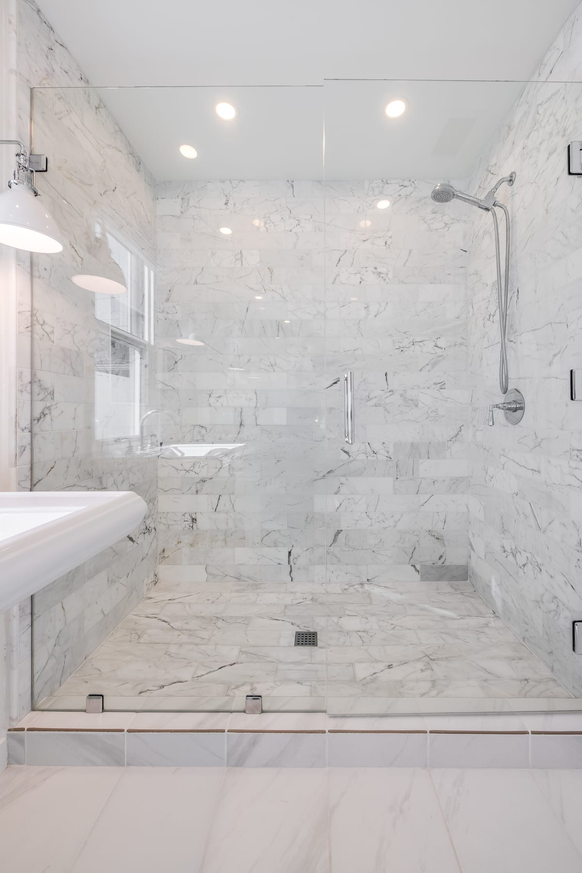 Marble walk-in shower with a frameless glass enclosure