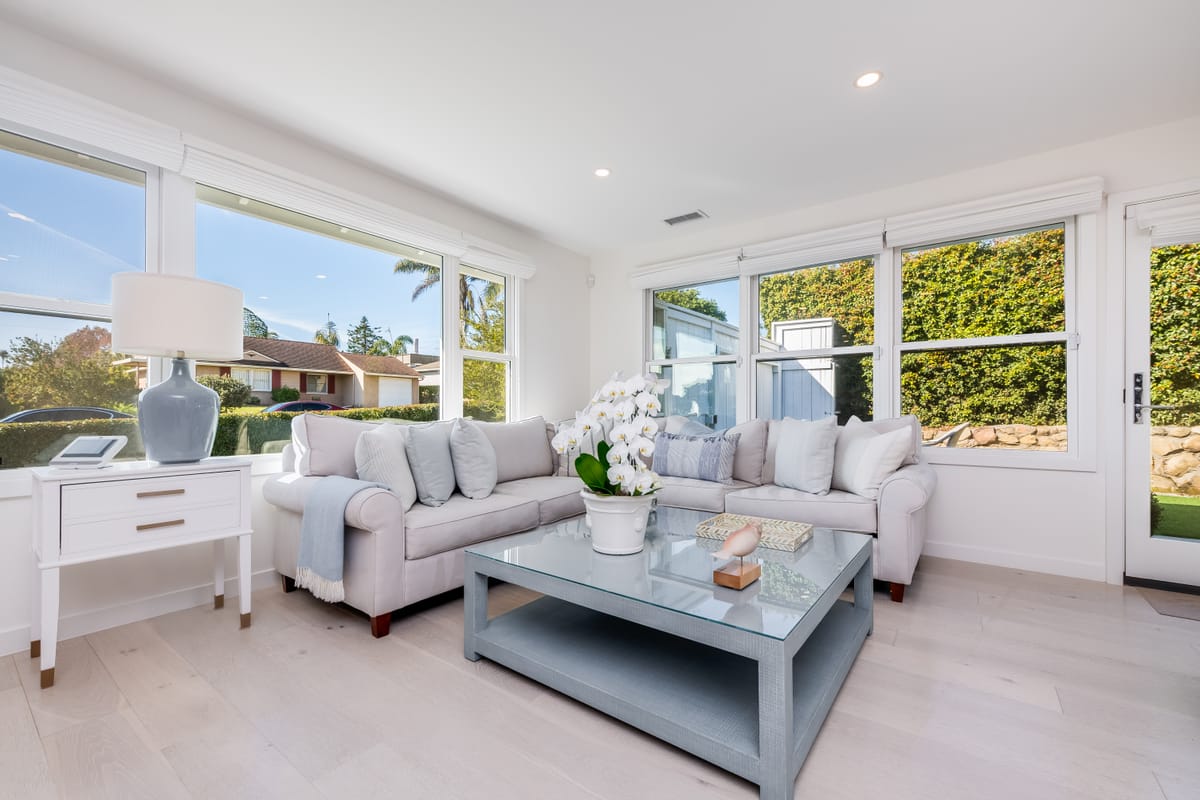 Sunlit living room with a sectional sofa and garden views