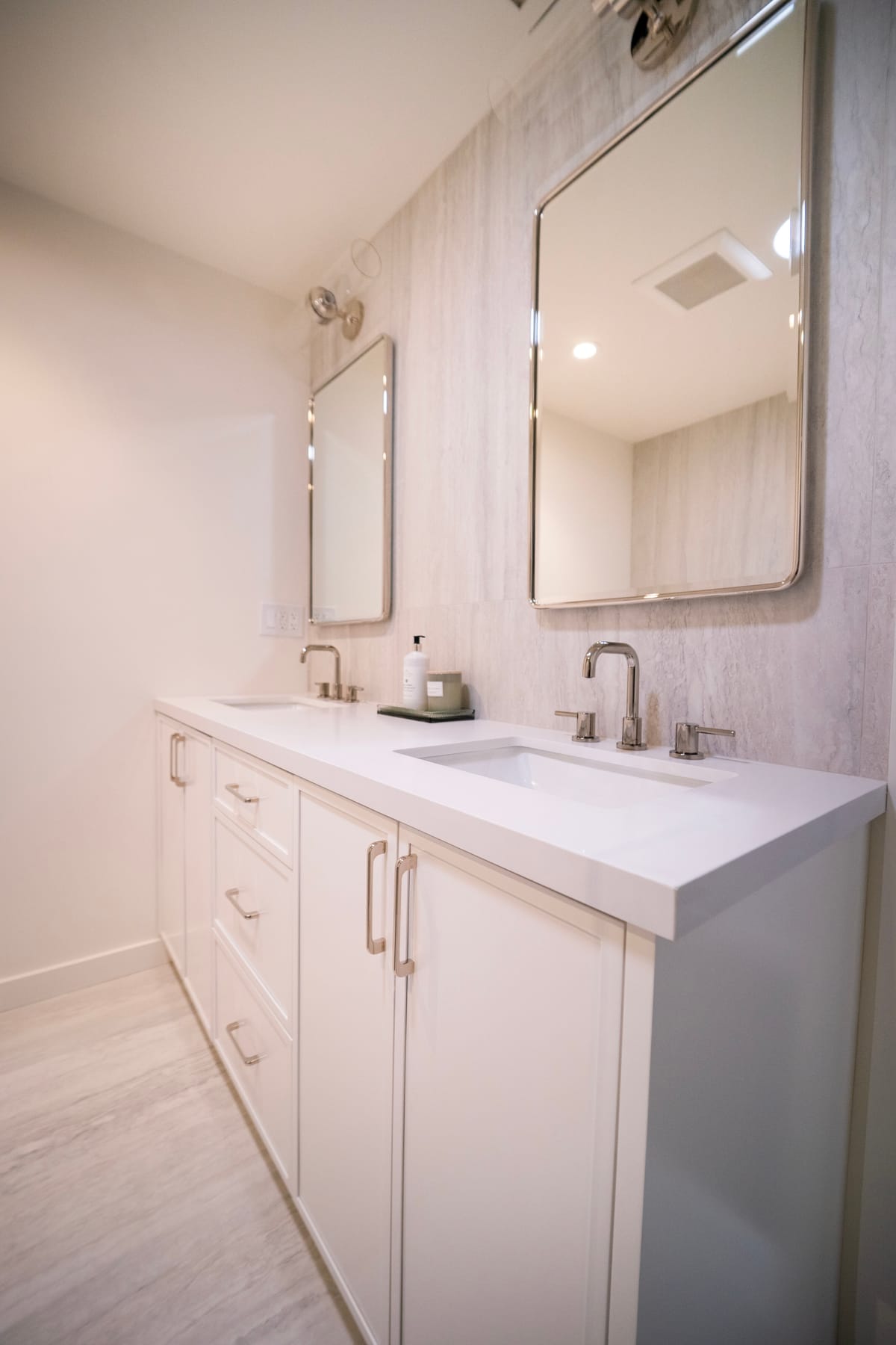 Double vanity with framed mirrors and a stone tile backsplash